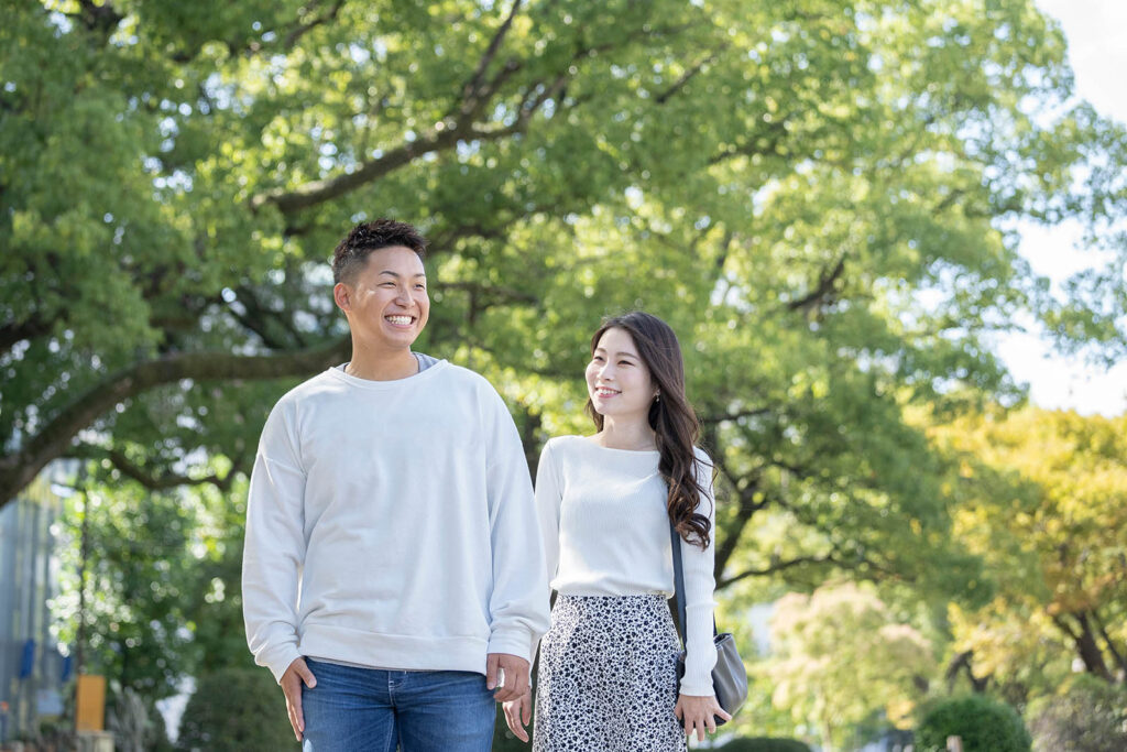 綺麗な緑を背景に仲良く歩く若い男女