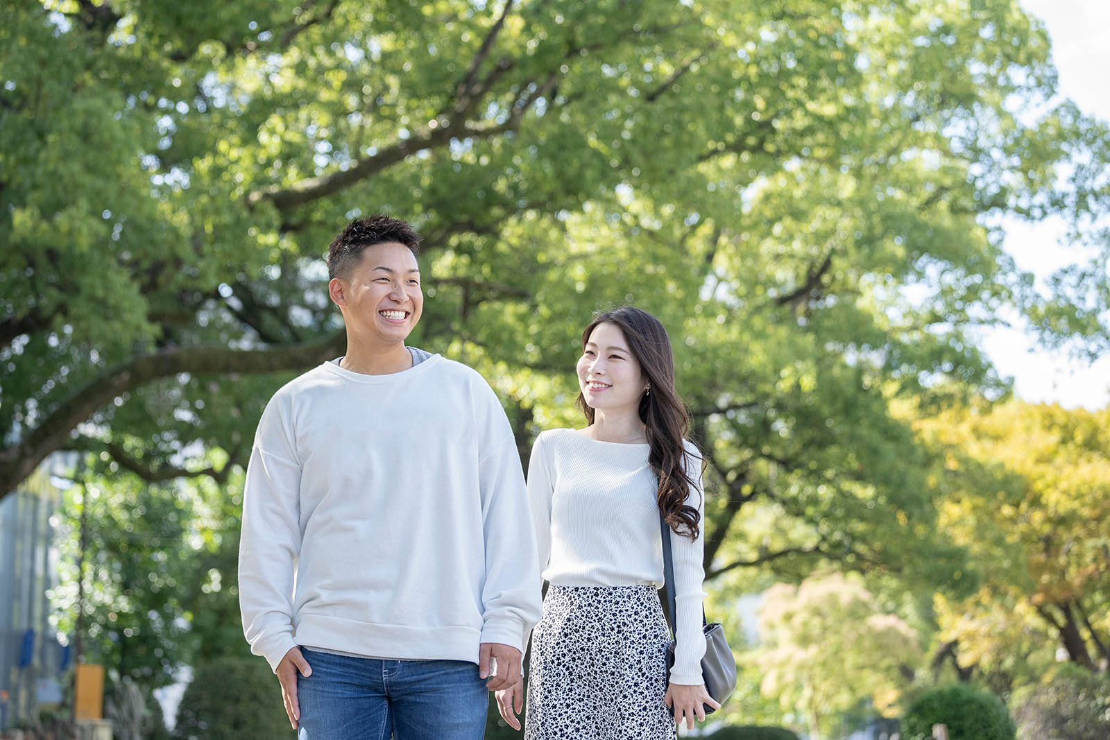 綺麗な緑を背景に仲良く歩く若い男女